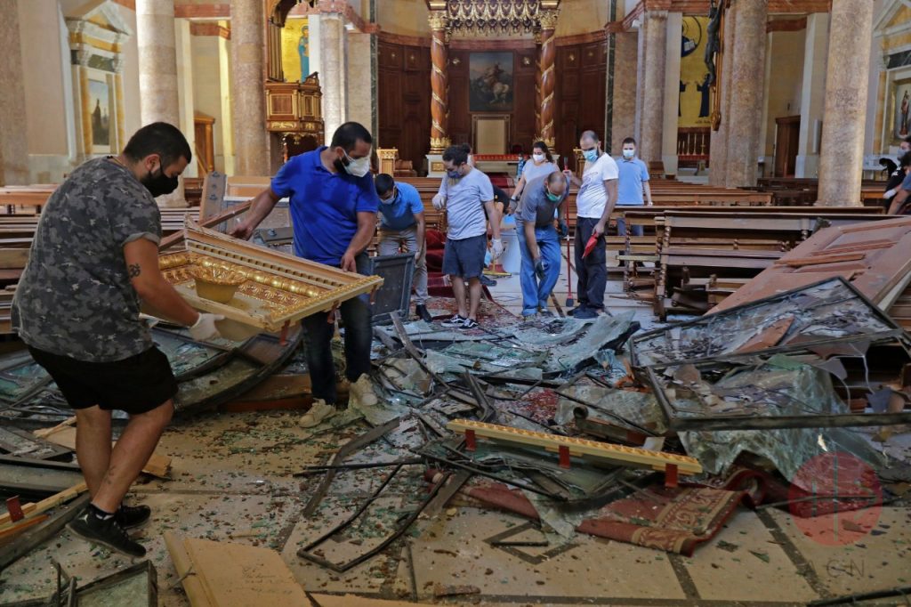 Jóvenes cristianos voluntarios que ayudan tras la explosión de la semana pasada a limpiar la catedral maronita dañada en Beirut