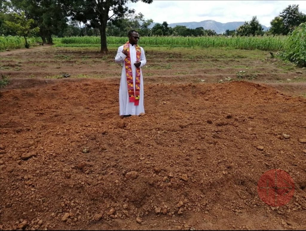 P. Sam Ebute en un terreno donde ha enterrado a sus feligreses asesinados. (ACN)