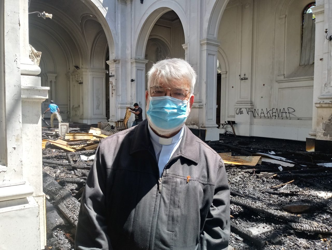 El párroco Pedro Narbona dentro de su iglesia incendiada en Chile. (ACN).