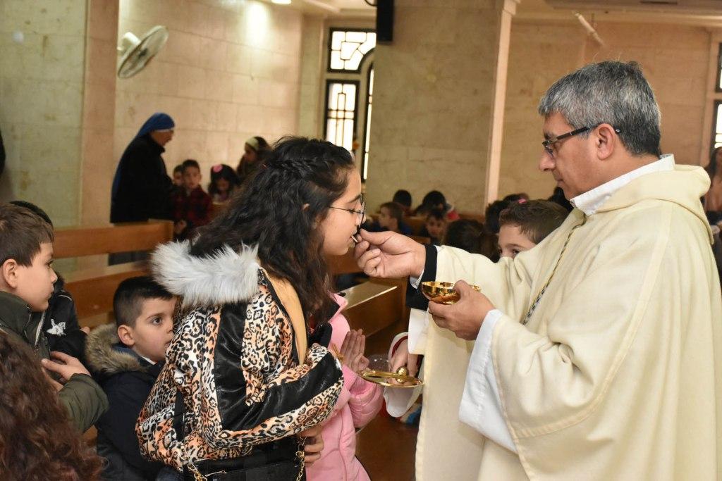 Un sacerdote repartiendo la comunión en una iglesia de Alepo, Siria. (ACN)