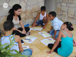 Una joven imparte catequesis a varios niños en el portal de una casa en Cuba(ACN)