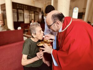 El padre Gabriel Romanelli da la comunión a una feligresa durante una Misa en la Parroquia de la Sagrada Familia (Gaza). © Holy Family Church Gaza