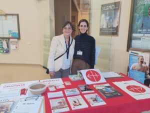 Dos voluntarias de ACN España en una mesa de información de la fundación
