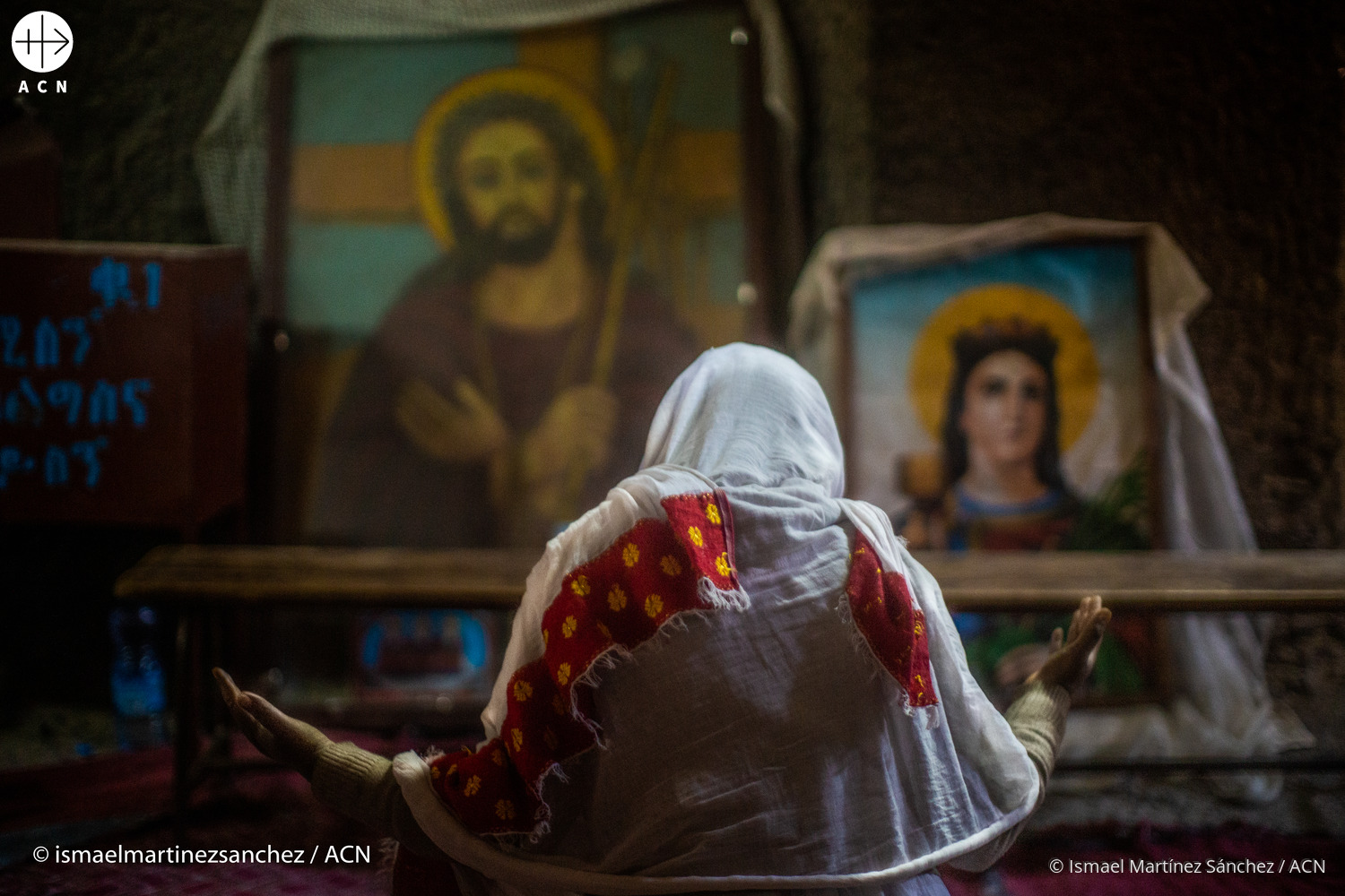Una mujer cristiana en Etiopía reza ante los iconos de Jesús y María
