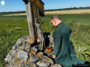 Un sacerdote arrodillado ante un crucifijo destruido en el este de Ucrania