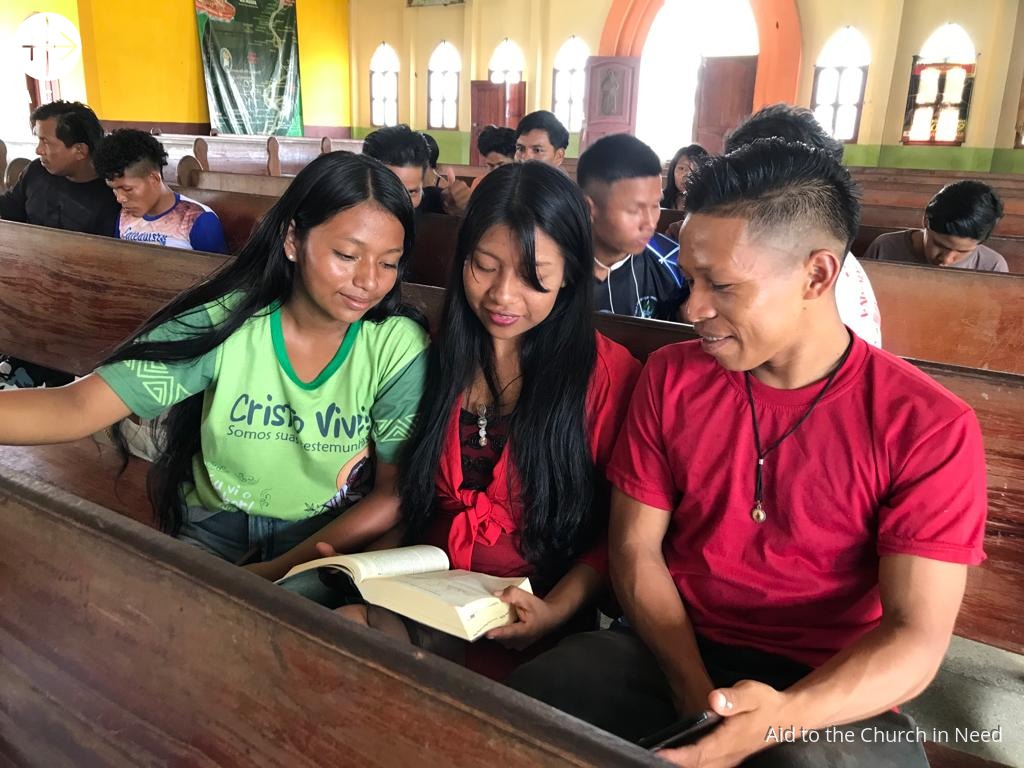 Jóvenes de una comunidad leyendo la Biblia durante la catequesis. Foto de archivo