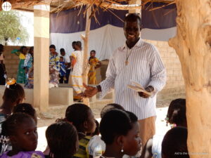 Mathieu sawadogo, catequista en Burkina Faso, impartiendo catequesis a un grupo de niños