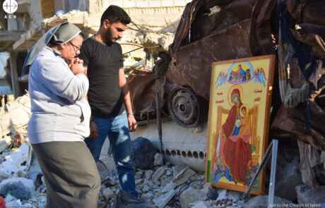 Un joven y una religiosa rezan ante un icono de la Virgen en Ghouta (Siria)