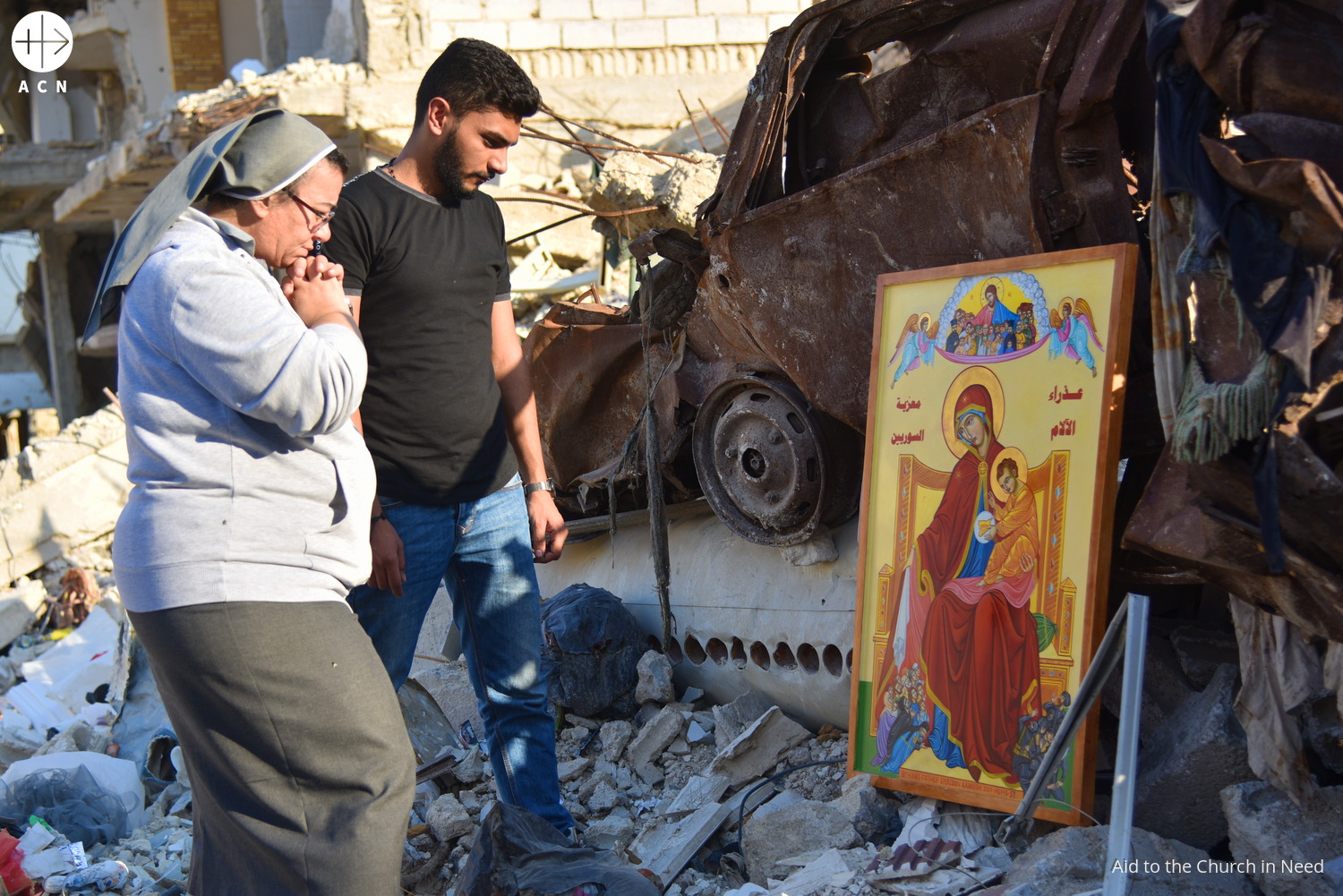 Un joven y una religiosa rezan ante un icono de la Virgen en Ghouta (Siria) Un joven y una religiosa rezan ante un icono de la Virgen en Ghouta (Siria)
