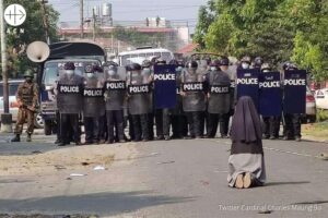 Una monja reza de rodillas enfrente de un grupo de policías en Myanmar Una monja reza de rodillas enfrente de un grupo de policías en Myanmar