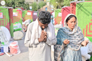 Dos personas rezando tras los ataques extremistas contra los cristianos en Jaranwala (Pakistán) en 2023