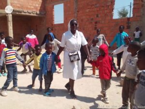 Monja misionera baila junto a un grupo de niños en Angola