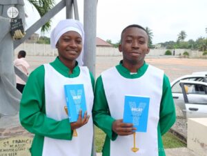 Dos jóvenes de Ghana con sus ejemplares del Docat