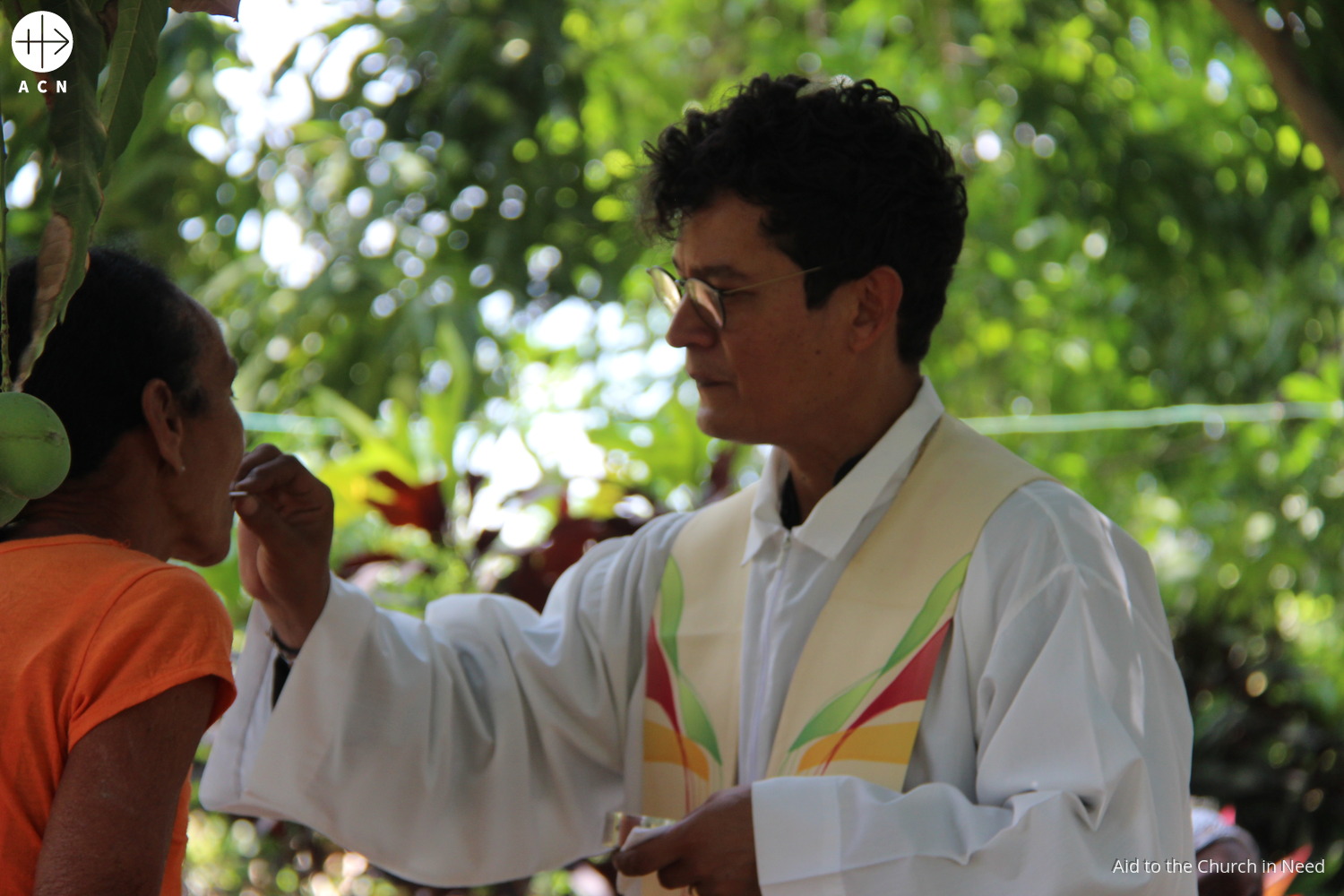 Sacerdote cubano distribuye la comunión a los fieles durante una Misa en Santiago de Cuba