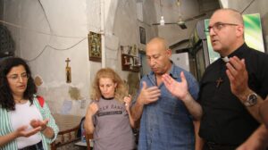 Un familia cristiana de Tiro reza junto a un sacerdote en su casa. (ACN)