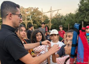Sacerdote con jóvenes durante las actividades en los campamentos de verano Sacerdote con jóvenes durante las actividades en los campamentos de verano