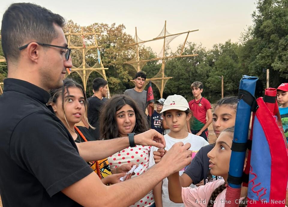 Sacerdote con jóvenes durante las actividades en los campamentos de verano